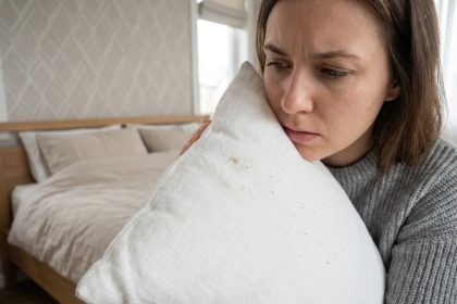 Jeune femme examine un oreiller blanc dans sa chambre moderne