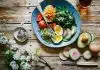 poached egg with vegetables and tomatoes on blue plate