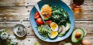 poached egg with vegetables and tomatoes on blue plate