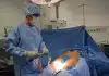 man in blue scrub suit holding white hose