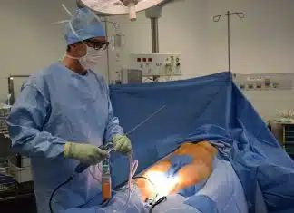 man in blue scrub suit holding white hose