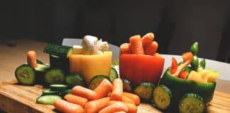 sliced carrots and green bell pepper on brown wooden chopping board